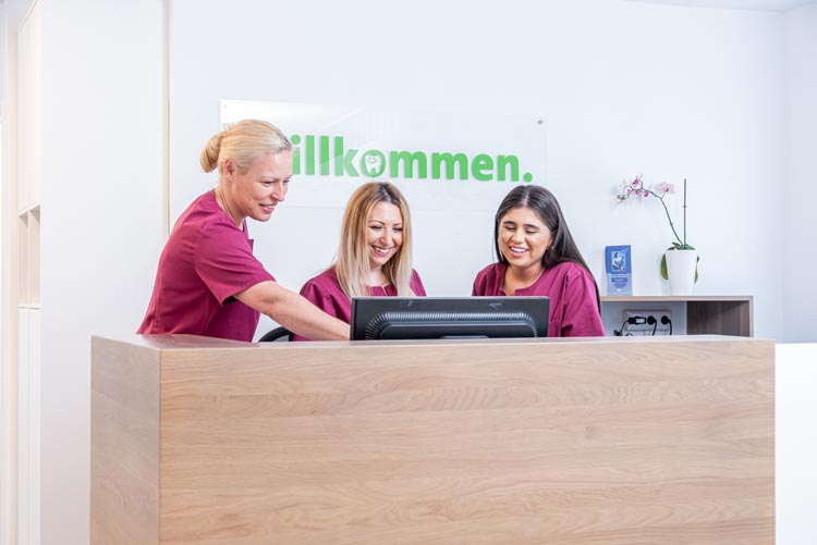 Neue Theke mit Gruppenbild der Zahnarztpraxis vom Zahnarzt Hauger und dem Zahnarzt Matziou